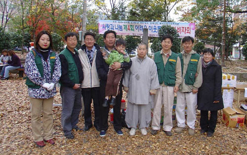 바자회를 주최한 천주교 마산교구 삼계 성당 이성렬(요셉) 신부(왼쪽에서 넷째, 아기를 안고있는 사람), 자비정사 진홍스님(왼쪽에서 다섯째), 호계문창교회 이상근 목사(왼쪽에서 여섯째) 